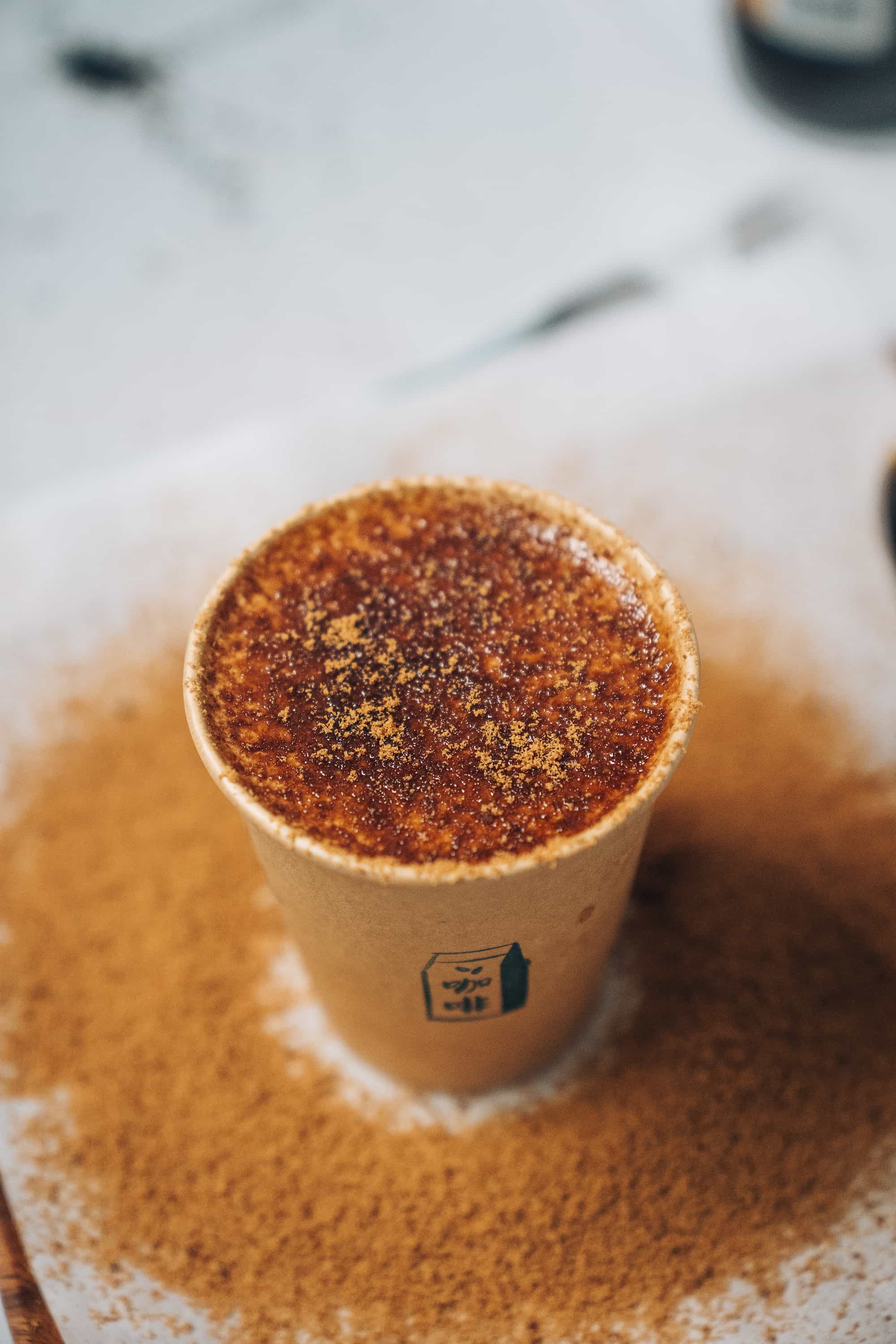 Top view of the brown sugar latte in a brown paper cup.